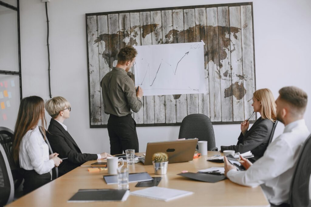 Group of business professionals discussing strategies with growth chart in conference room.